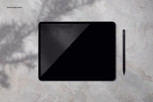 Flat lay of an iPad Pro mockup and pen on a textured gray background with natural shadow effects.
