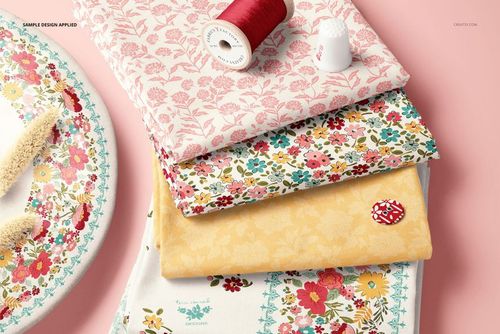 Fabric stack mockup featuring four folded textiles in floral and botanical prints, displayed with thread and thimble.