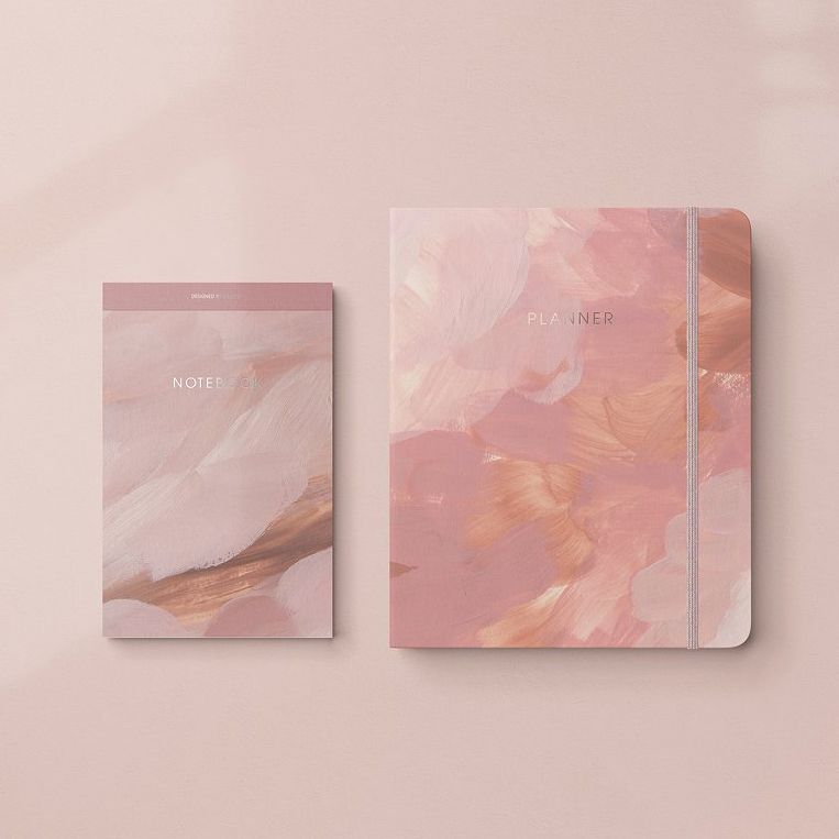 Stationery mockup showing a notebook and planner with abstract blush and pink brushstroke covers on a soft pink background.