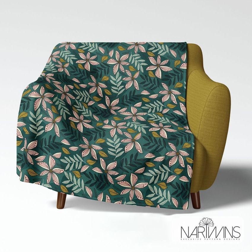 Fleece throw blanket mockup draped over a mustard yellow armchair, featuring a bold floral pattern on a dark green background.
