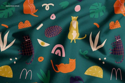 Close-up of a pet bandana mockup featuring colorful cat drawings and geometric patterns on green material.