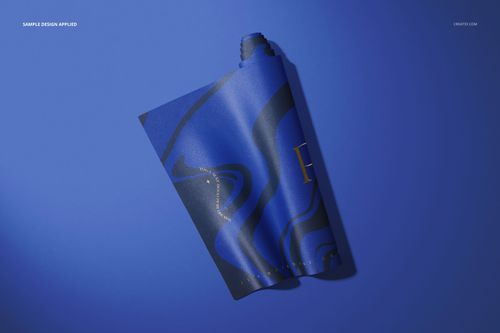 Rolled yoga mat with abstract blue and black pattern displayed on a solid blue surface, top view mockup.