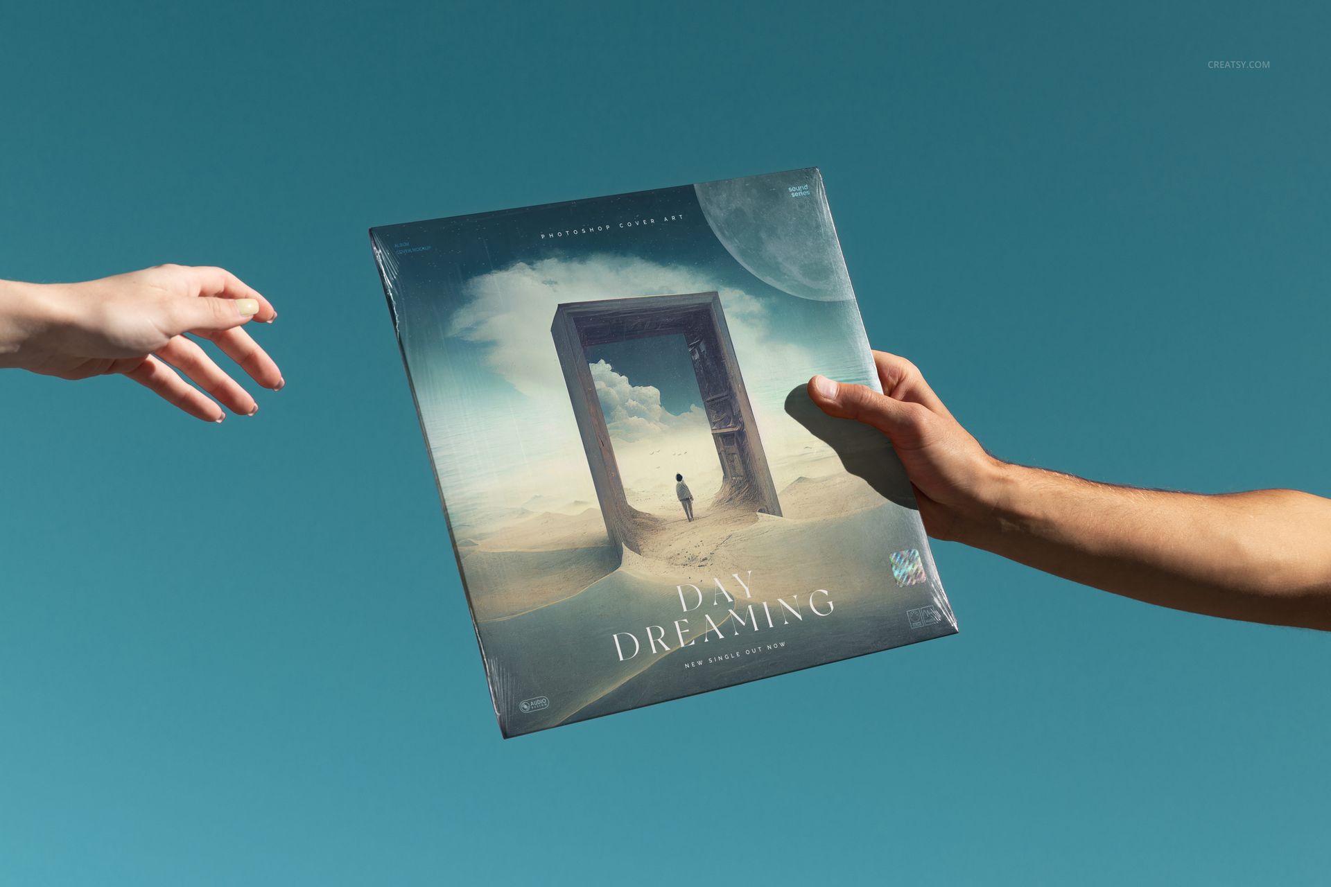 Vinyl record mockup featuring a square album cover with dreamlike artwork, held by two hands on a blue background.