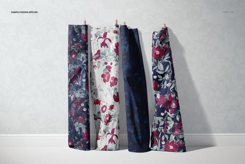Fabric rolls mockup showing floral prints in blue, red, and white, arranged vertically with a subtle patterned wall behind.
