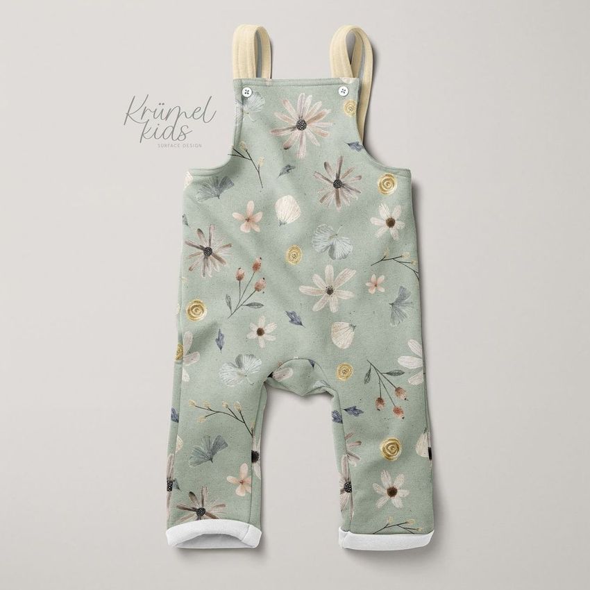 Kids fleece dungarees mockup featuring a pastel green fabric with a boho floral pattern, displayed on a neutral background.
