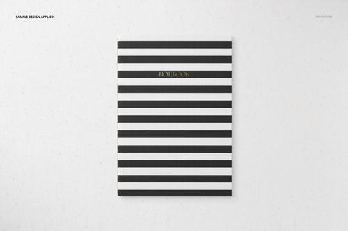 Stationery set mockup featuring a striped notebook with black and white lines and gold lettering on the cover.