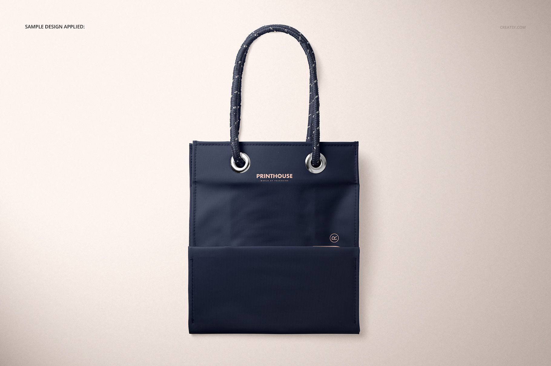 Front view of a matte PVC reusable tote bag mockup in dark blue with stitched handles, displayed on a light background.