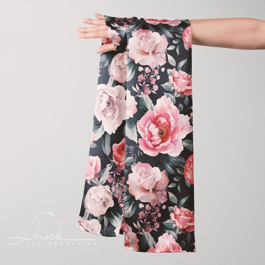 Silk scarf mockup draped over an outstretched hand, featuring a floral pattern with pink peonies and roses on a dark background.