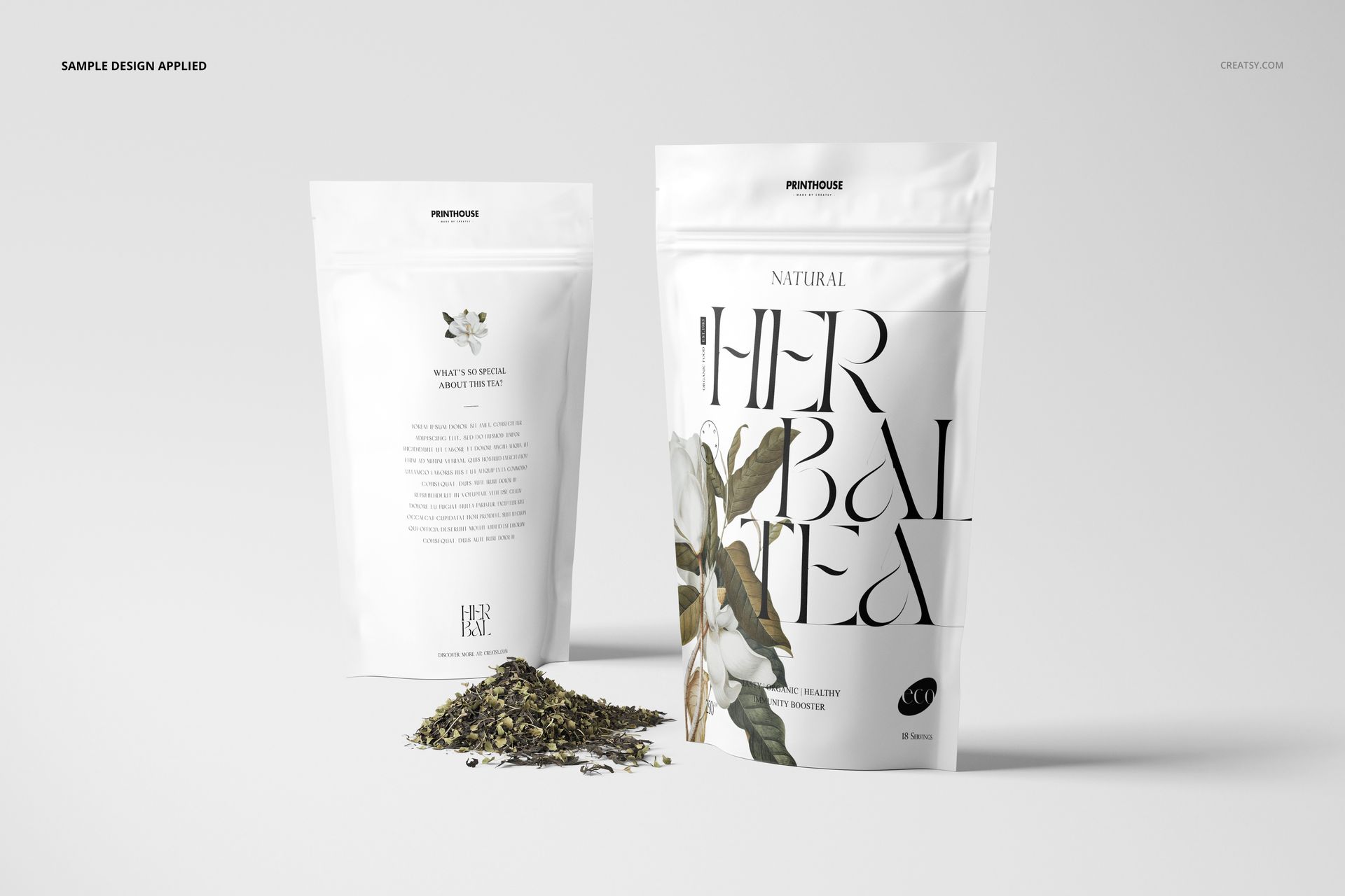 Stand up zip lock bag PSD mockup set featuring two white bags with elegant floral artwork and tea leaves on a light surface.