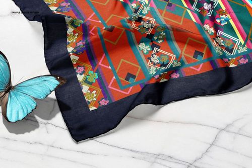 Colorful silk scarf mockup featuring bold geometric shapes and flowers, displayed partially folded on marble.