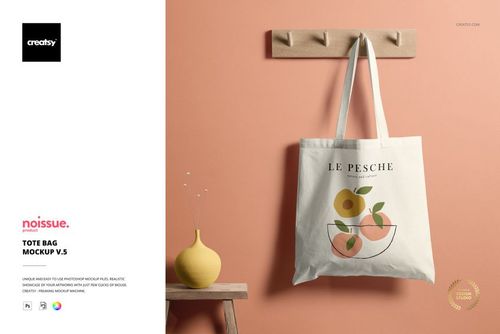 White tote bag mockup featuring a minimalist fruit illustration, displayed on a wooden peg rail with a peach wall.