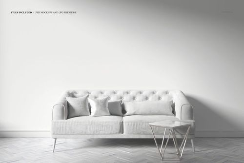 PSD mockup showing a stylish art deco sofa with soft upholstery, two cushions, and a sleek side table against a blank wall.