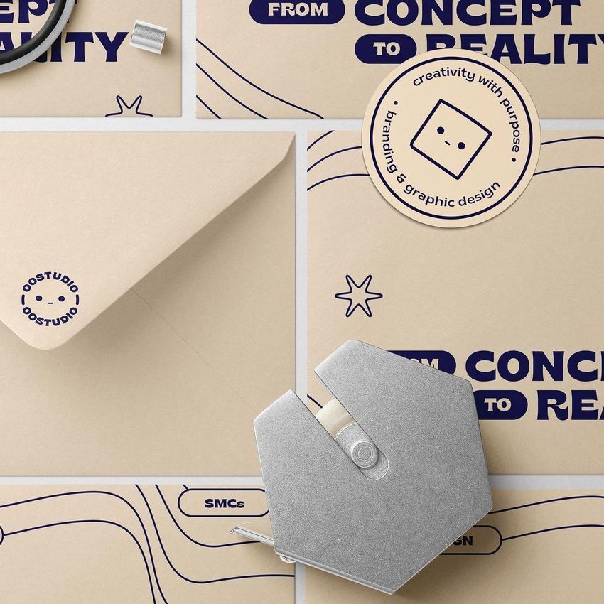 DL envelope mockup with beige stationery items, navy blue text overlays, a round sticker, and a metal tape dispenser on a flat surface.