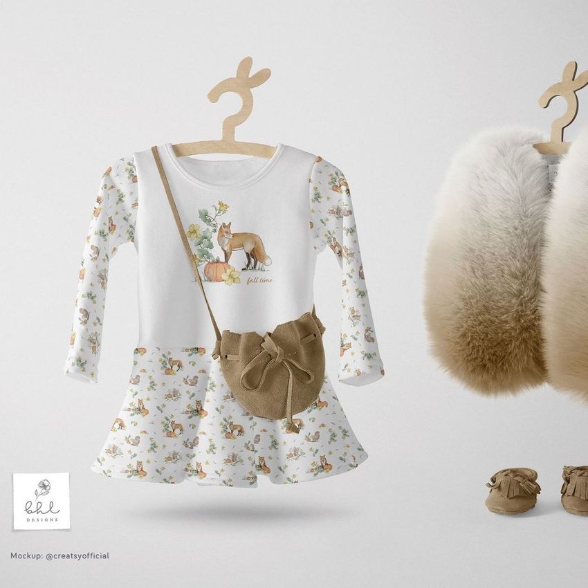 Baby dress mockup featuring a long-sleeve dress with autumn-themed patterns, a small brown bag, and fur-lined shoes on a light background.