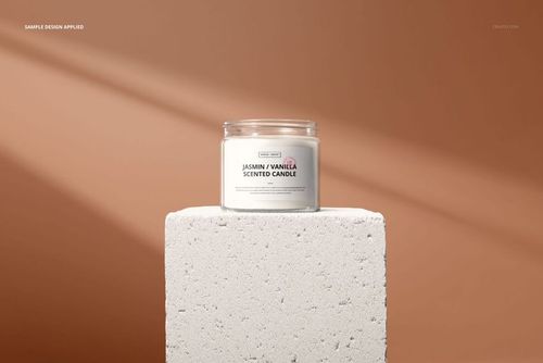 Minimalist jar candle mockup featuring a clear glass container with a white label, set on a stone block, front perspective.