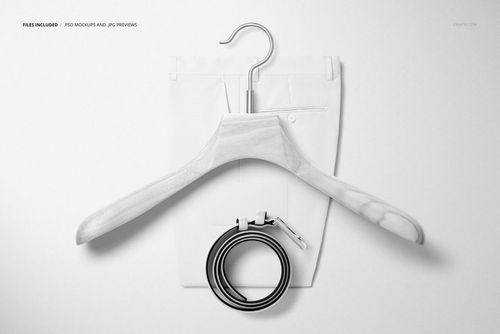 PSD mockup featuring men’s trousers, a wooden hanger, and a rolled leather belt arranged on a white surface.
