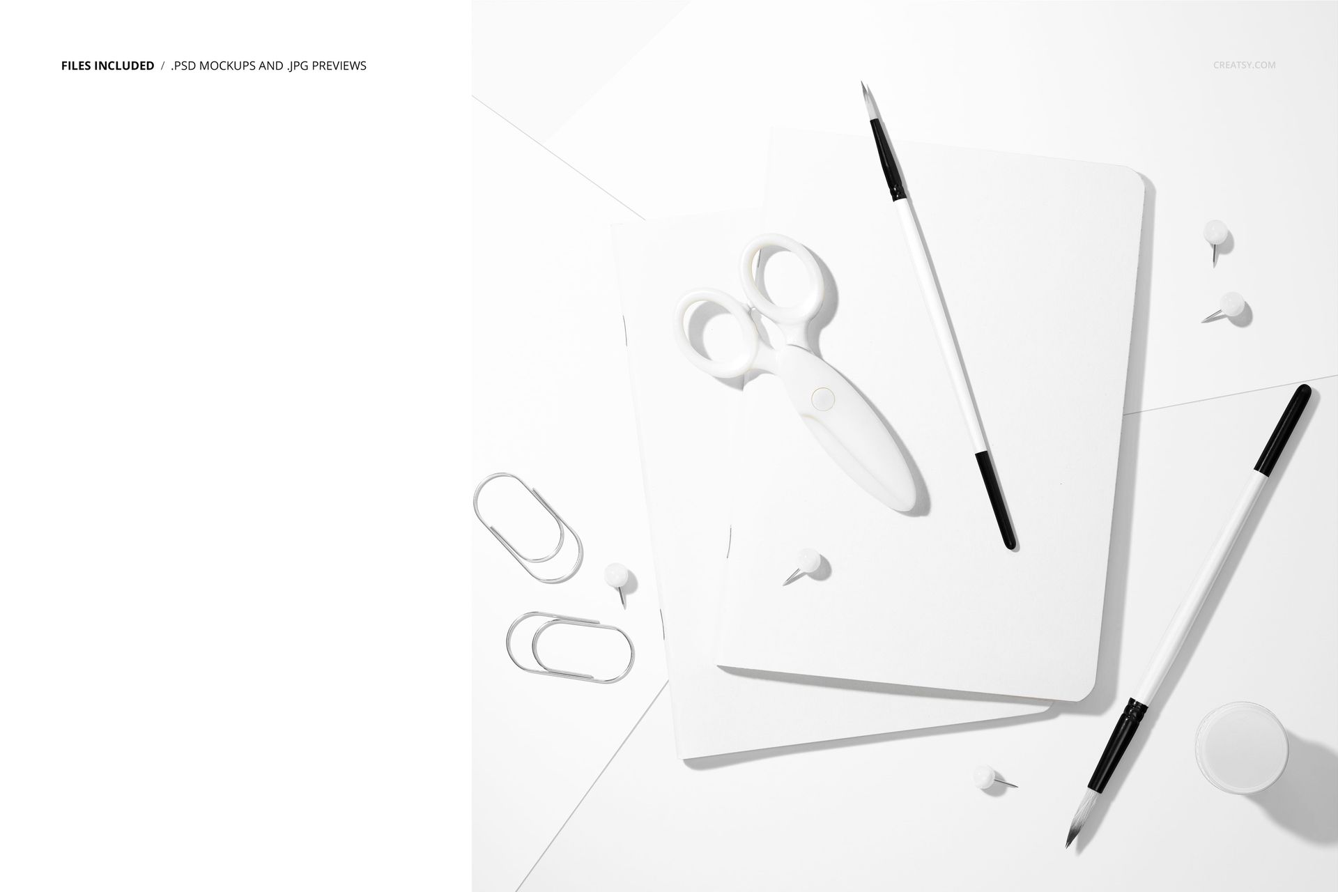 Stationery mockup featuring two plain notebooks, scissors, paintbrushes, and office supplies on a white background.
