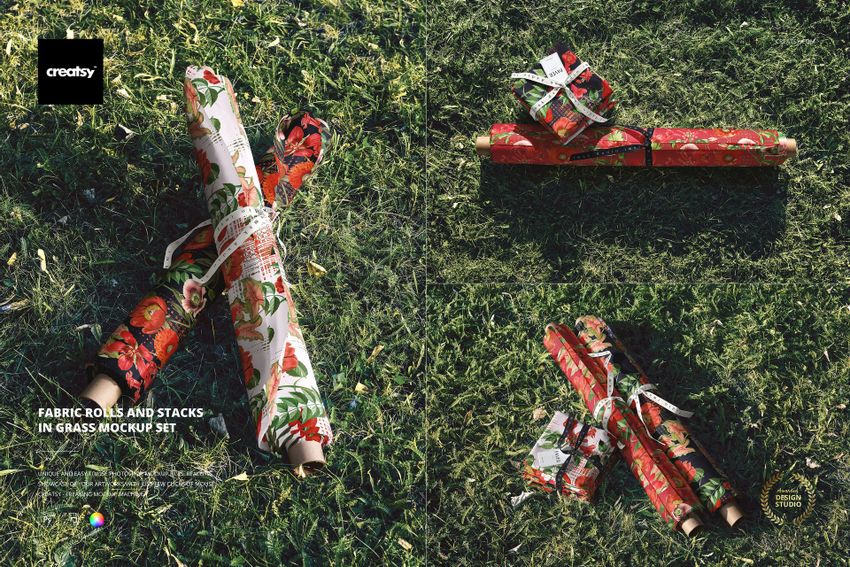 PSD mockup showing patterned fabric rolls and stacks with red and white designs lying on sunlit grass.