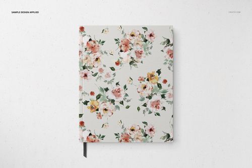 Stationery mockup featuring a closed notebook with a watercolor-style flower design, viewed from above on a white surface.
