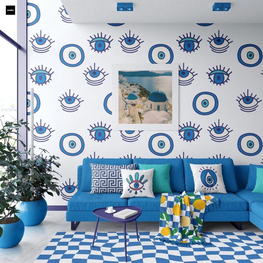 Modern living room sofa mockup featuring a blue couch with patterned pillows, a geometric rug, and a wall decorated with blue evil eye motifs.