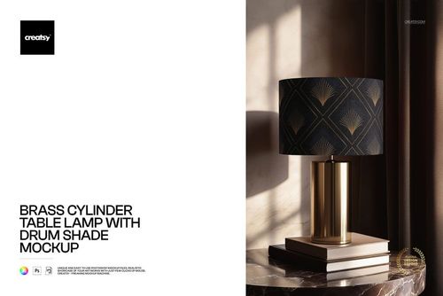 PSD mockup of a brass cylinder lamp featuring a black drum shade with gold accents, placed on stacked books.