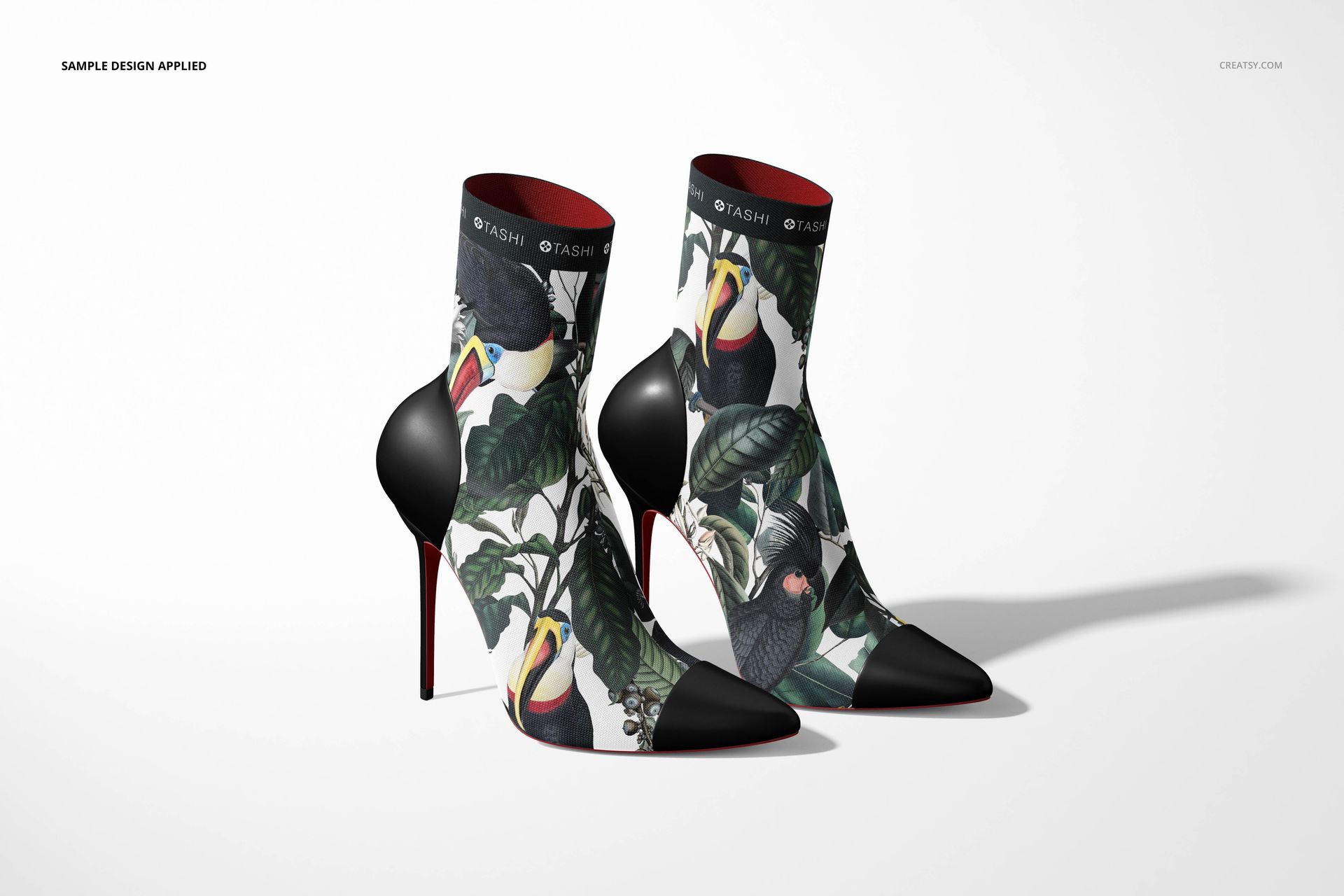 Fabric ankle boots mockup with black heels and vivid toucan print, presented in a realistic studio setting.