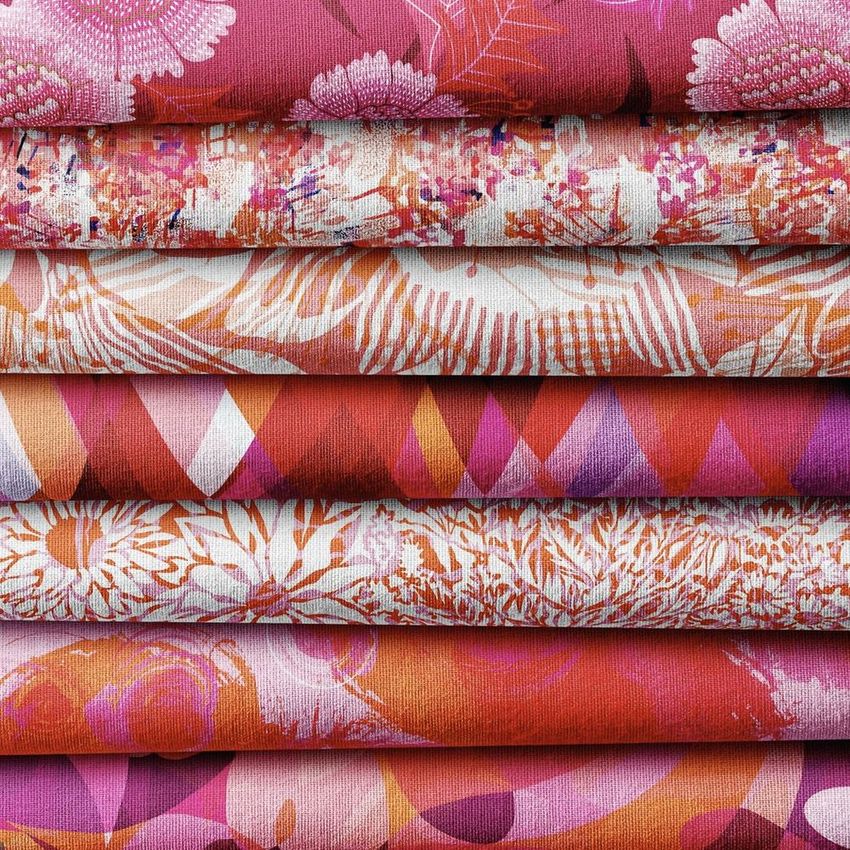 Fabric stack mockup showing six folded textiles with various pink, red, and orange botanical and abstract patterns in close-up.