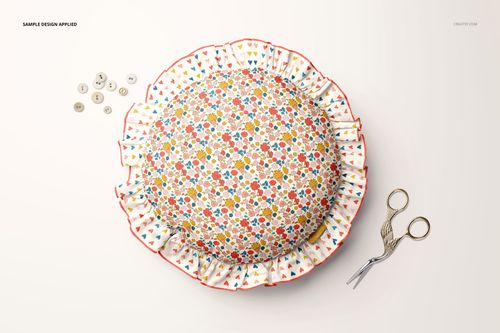 Top view of a circular pillow featuring ruffled edges and a multicolor floral design, mockup scene with sewing props.