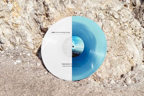 Vinyl record mockup displayed on rocky ocean shore, showing half white and half blue record with editable label.