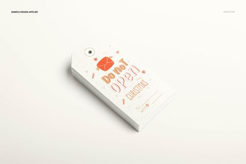 Paper labels mockup set showing a pile of tags with printed holiday graphics, viewed from the front on a light background.