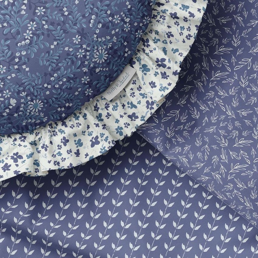 Ruffled pillow mockup featuring a round cushion with blue and white floral patterns, shown on patterned fabric backgrounds.