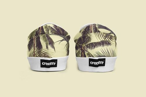 PSD mockup of slip-on shoes with a leafy palm tree design, displayed from the back against a neutral beige background.