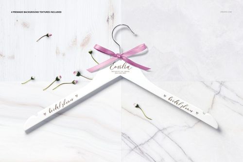 Personalized white hanger mockup with elegant script, pink bow, and small flowers on a split marble and wood surface.