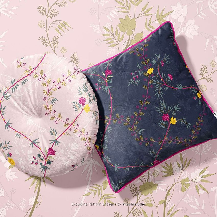 Square and round velvet cushions with piping, featuring floral patterns in pink and navy, placed on a matching floral background.