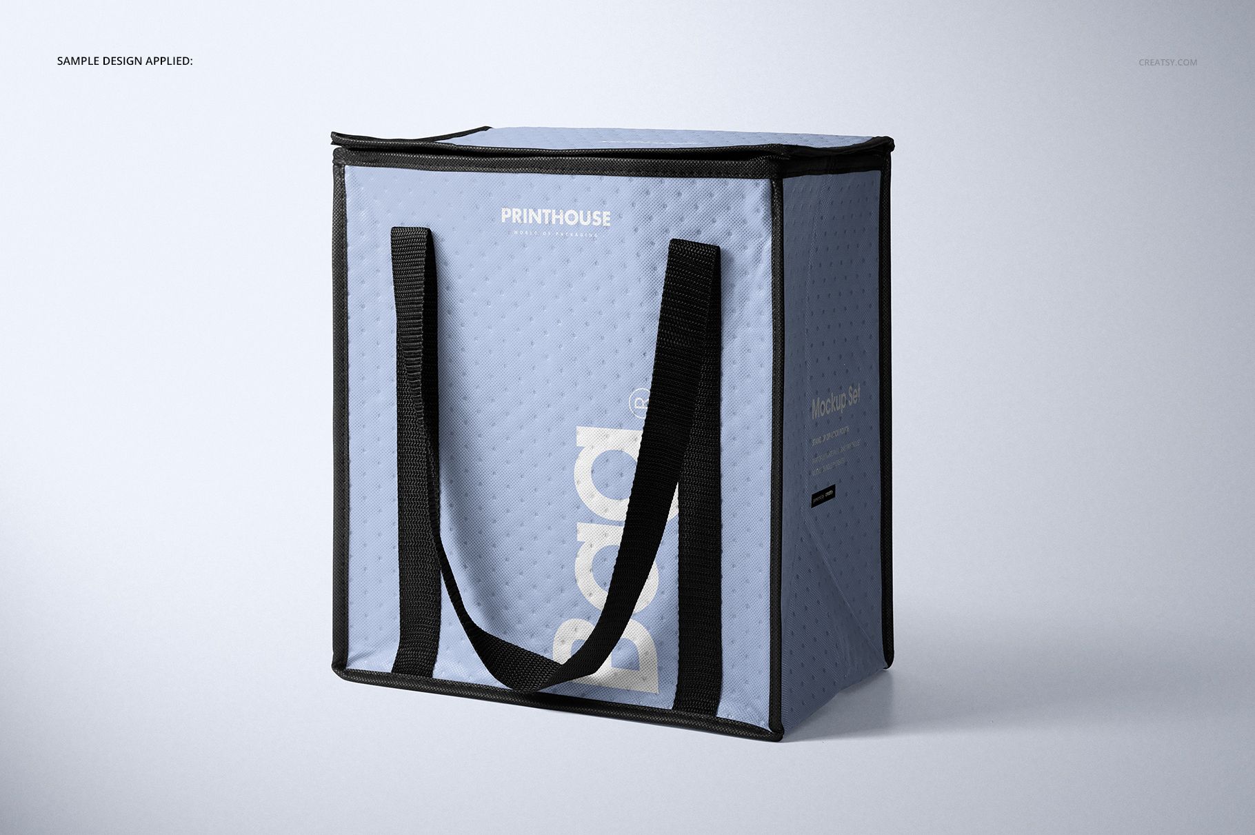 Front angled view of a light blue insulated cooler bag mockup with black handles and subtle textured surface.