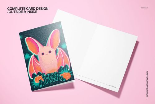 Halloween card mockup showing a vibrant bat and pumpkin design on the cover, with blank interior, placed on a pink background.
