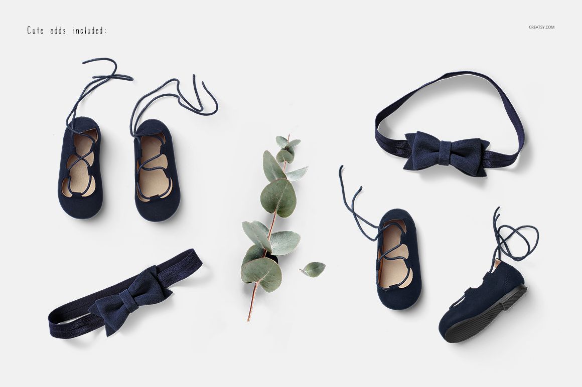 Navy blue baby dress accessories mockup set featuring shoes, headbands, and a sprig of eucalyptus on a white background.