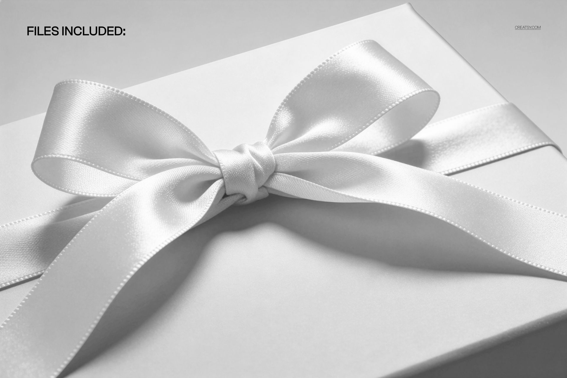 Premium gift box mockup featuring a glossy white satin ribbon tied in a bow, viewed from the front and slightly above.