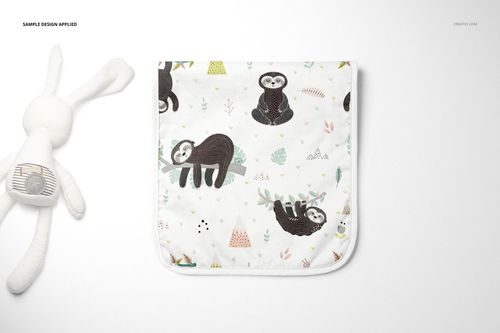 PSD mockup of a minky burp cloth with illustrated sloths and trees, displayed flat with a plush toy on a light background.