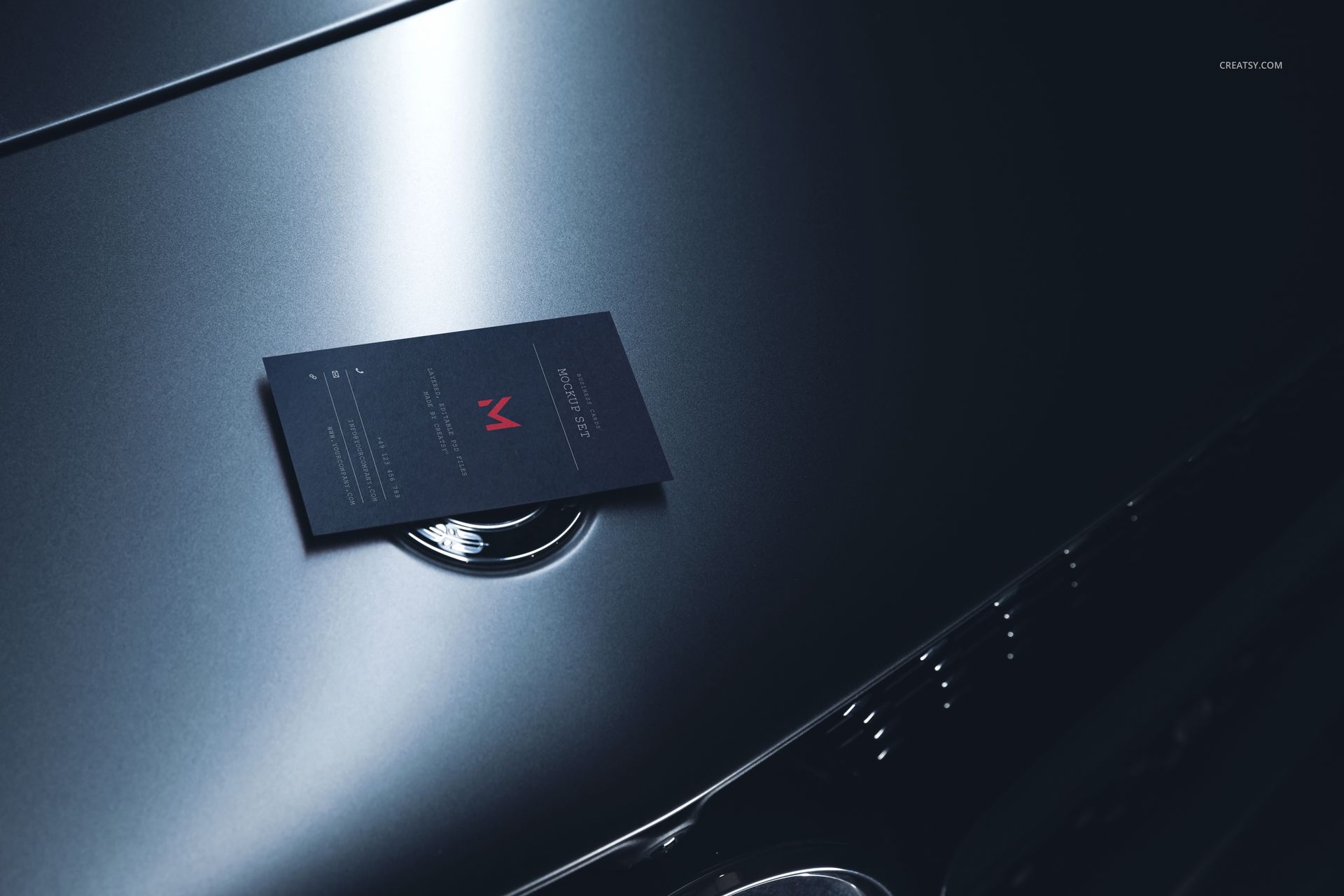 Automotive-themed business card mockup featuring a dark card resting on a glossy car hood, side perspective.