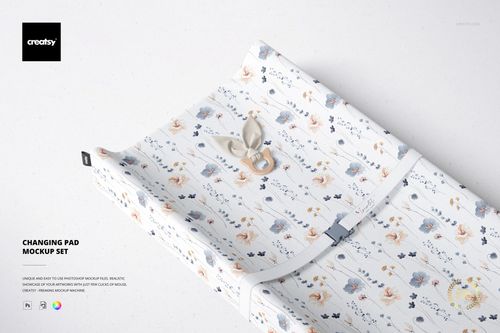 PSD mockup of a baby changing pad featuring a whimsical pattern, viewed from above with a pacifier accessory.