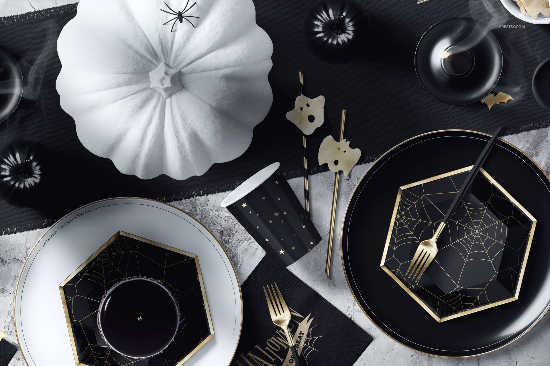 Halloween table setup mockup featuring black and white plates with spiderweb patterns, gold cutlery, and festive props.