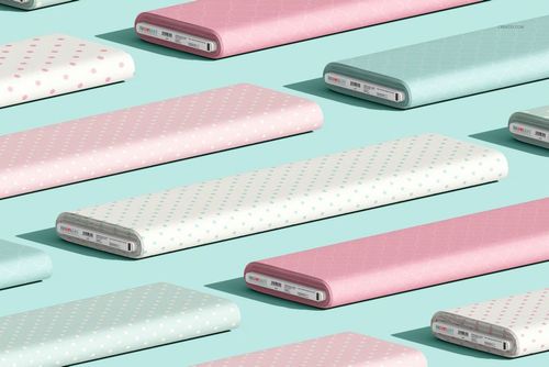 Pastel-colored fabric bolts with polka dot prints, shown from an angled perspective on a light blue tabletop in a mockup scene.