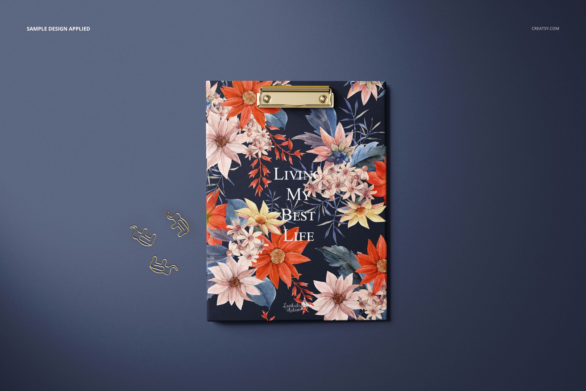 Stationery clipboard mockup with gold clip, decorated with vibrant flowers and text, displayed on a blue backdrop.