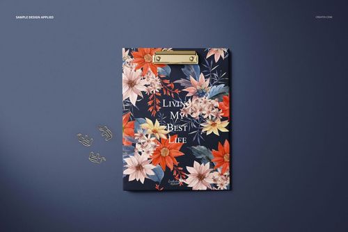 Stationery clipboard mockup with gold clip, decorated with vibrant flowers and text, displayed on a blue backdrop.