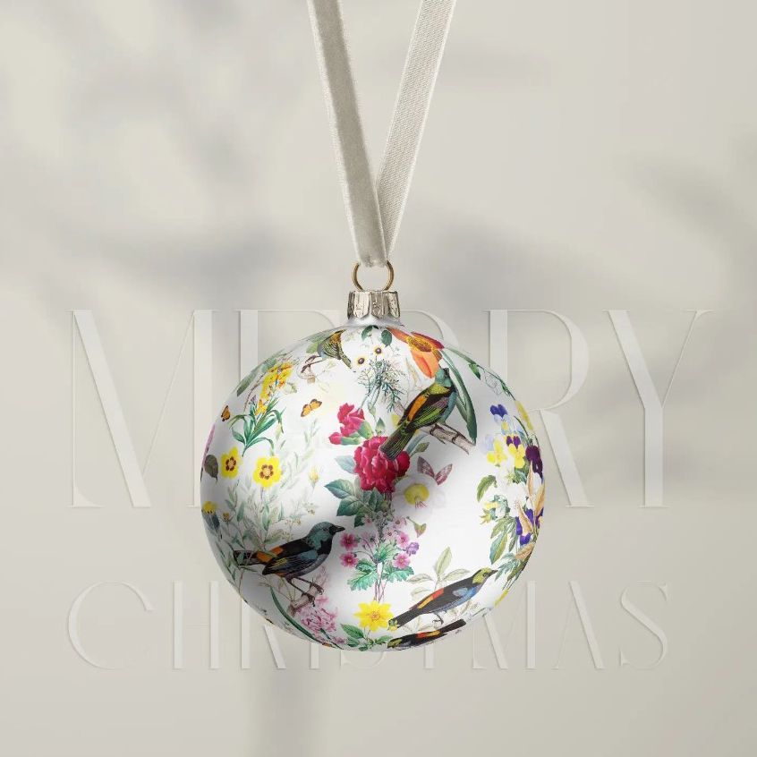 Satin Christmas ball mockup featuring a white ornament with colorful bird and floral illustrations, hanging by a velvet ribbon.