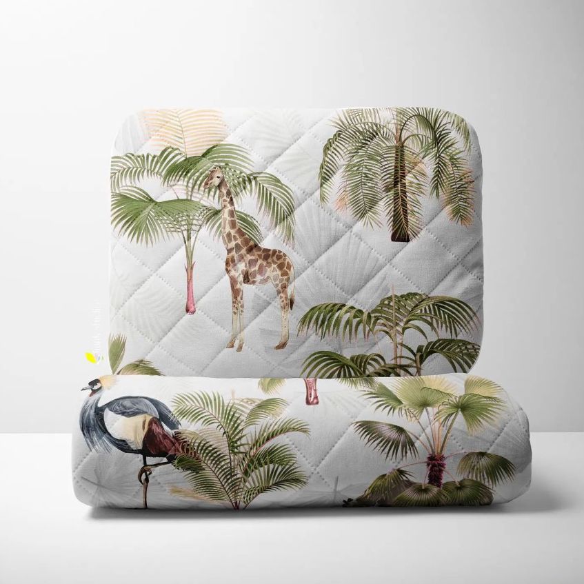 Double-sided baby bedding set mockup showing a quilt and pillow with tropical palm trees, a giraffe, and a bird on a white background.