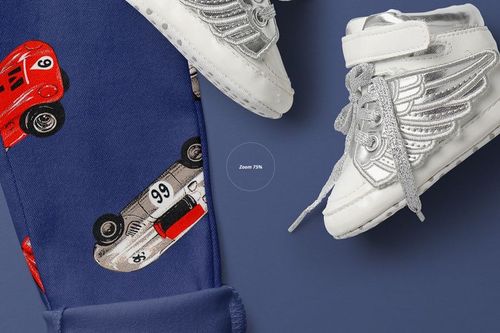 Kids trousers mockup with blue fabric featuring red and silver race car prints, shown next to white winged sneakers.