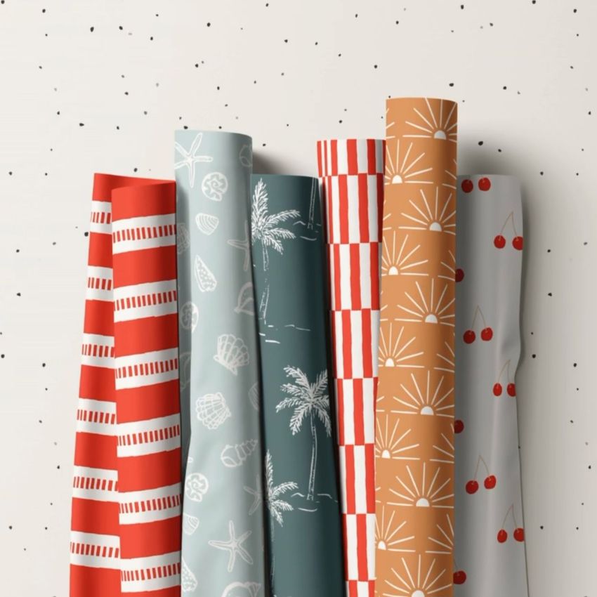 Fabric rolls mockup featuring six rolls with various beach-themed and geometric patterns in red, blue, and tan tones.