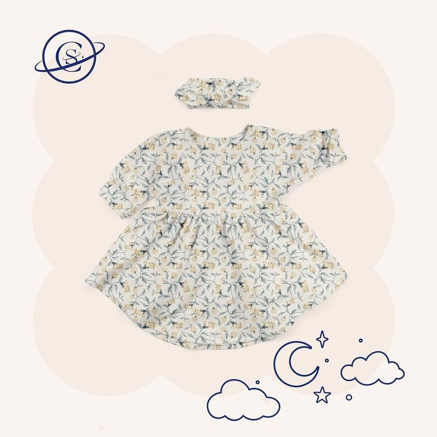 Baby jersey dress mockup with matching headband, featuring a floral pattern on a light background with celestial doodles.